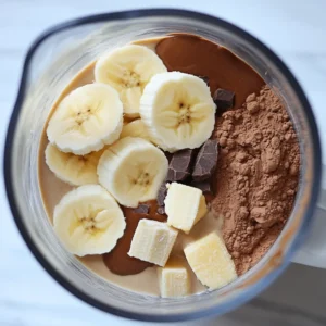 Banana, peanut butter, cocoa, and protein powder added to blender