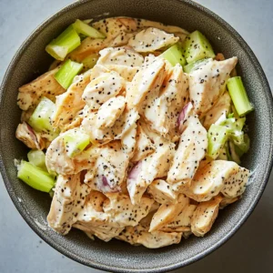 Folding chicken and vegetables into Greek yogurt dressing for high protein chicken salad